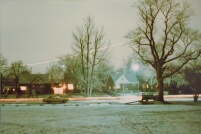 My house in Winter, behind tall center tree.  Light trail of plane approaching Detroit Metro Airport.  97kb